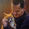 Shining light from left on Andy Meddick holding a dingo puppy in his arms.